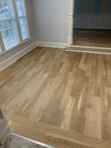 Detailed view of a hardwood floor installation with a clean transition by Peach Design Inc. in Atlanta, GA.