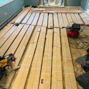 Bundles of hardwood planks laid out in a room, ready for installation by Isad Home Floor in Bridgeport, CT.