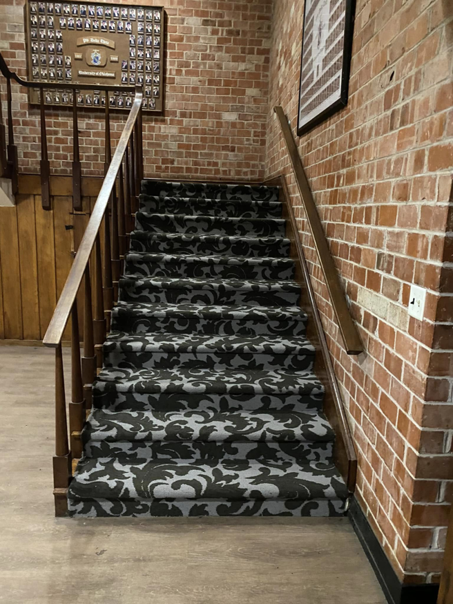 A head-on view of a beautifully installed patterned carpet on a staircase by Top Quality Floors LLC in Oklahoma City, OK.