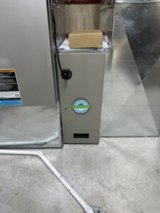 A Healthy Climate air purification unit installed alongside a furnace by Dischler Heating-Cooling & Fireplaces in Prairie du Sac, WI.