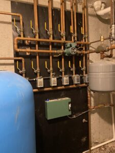 A heating manifold system installation with copper pipes and pumps by Excel Mechanical and Construction LLC in Brunswick, ME