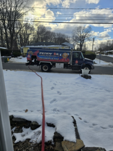 A Penny Oil Energy Distributors LLC truck delivering heating oil to a home in Waterbury, CT, during winter.