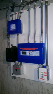 A heating system control panel installed by Versatile Services, clearly showing their contact information in Auburn, ME.