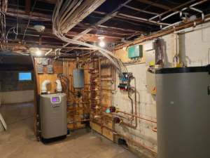 A comprehensive heating system installation with a new boiler and water heater in a basement by RSC Heating and Air Conditioning in Lancaster, PA.