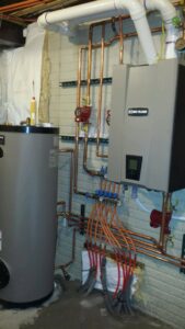 A newly installed heating system with a boiler, water heater, and copper piping by David J. Winston Co. in Erie, PA.