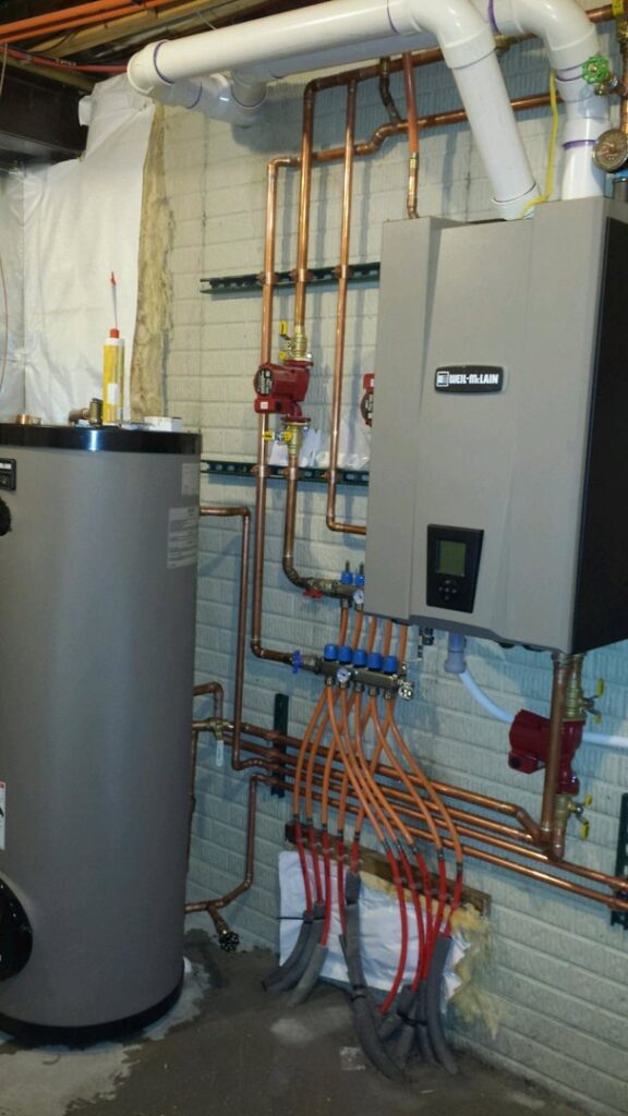 A newly installed heating system with a boiler, water heater, and copper piping by David J. Winston Co. in Erie, PA.