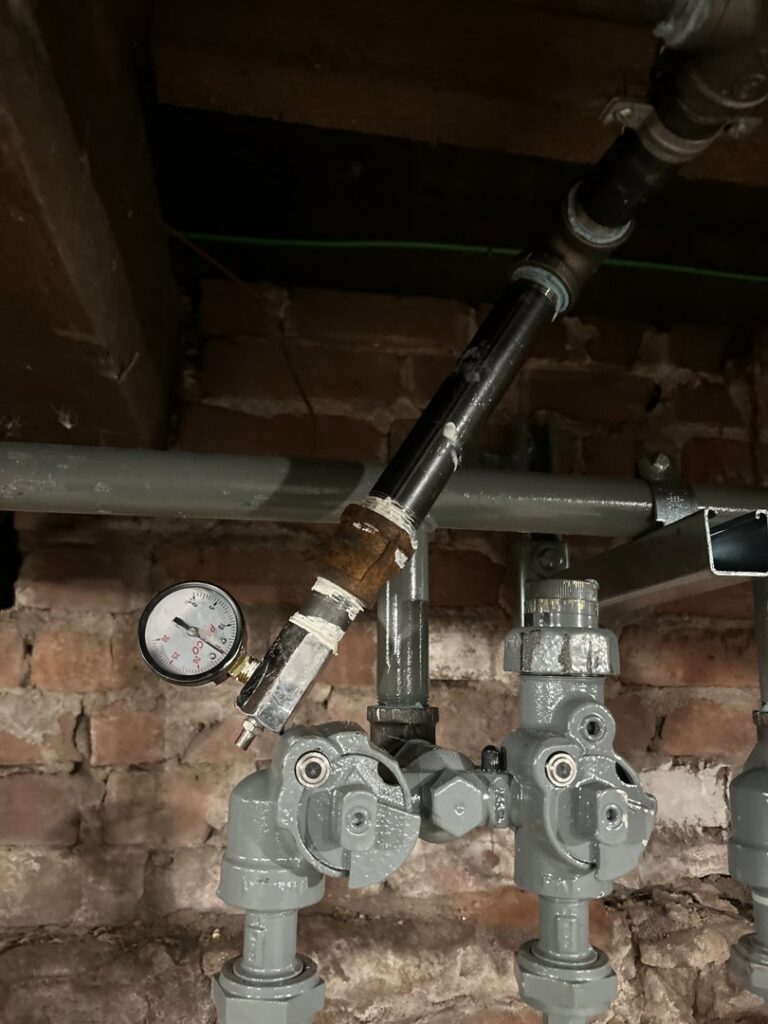 Close-up of heating system pipes and a pressure gauge being serviced by Express Home Services LLC in Las Vegas, NV