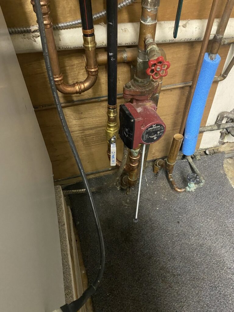 Pipes, valves, and a Grundfos pump, part of a heating system serviced by Coe Heating & Air Conditioning in Fort Wayne, IN.