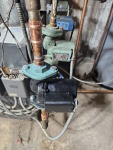 A close-up of a pump and copper pipes, part of a heating system serviced by Tony Marzano Plumbing & Heating LLC in Hartford, CT.