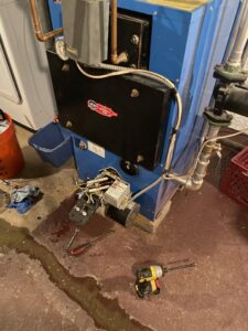 A heating system boiler undergoing repair with components exposed and tools nearby by Kane Heating & Air in Mountain Top, PA.