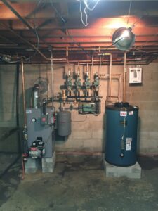 A complete heating system with boiler and blue hot water tank installed by JLP Heating & Cooling in Norwalk, CT