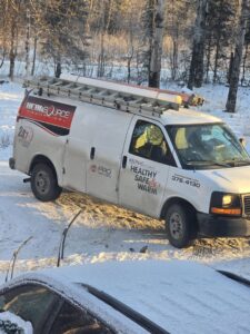 A HeatSource Mechanical service van parked in a snowy residential area in Wasilla, AK.