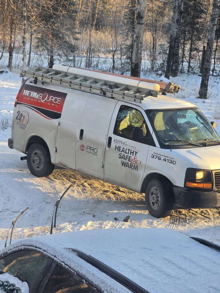 A HeatSource Mechanical service van parked in a snowy residential area in Wasilla, AK.
