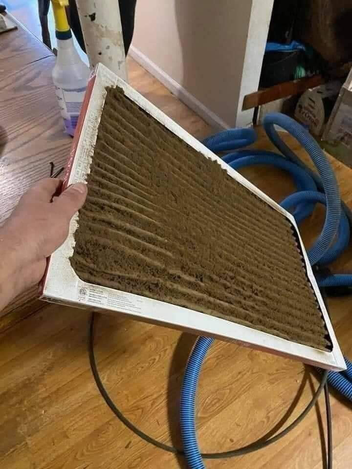 A hand holding a heavily clogged and dirty air filter, showing the need for HVAC cleaning by JJ Duct Cleaning in Aurora, IL