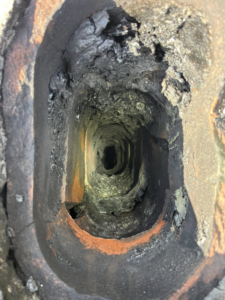An inspection view looking down a heavily sooted and creosote-filled chimney flue by Heartland Chimney Sweeps LLC in McCall, ID.