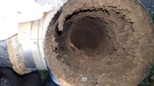 A close-up view of heavy creosote buildup inside a chimney flue, requiring professional sweeping by Chimney Karma in Fort Collins, CO.