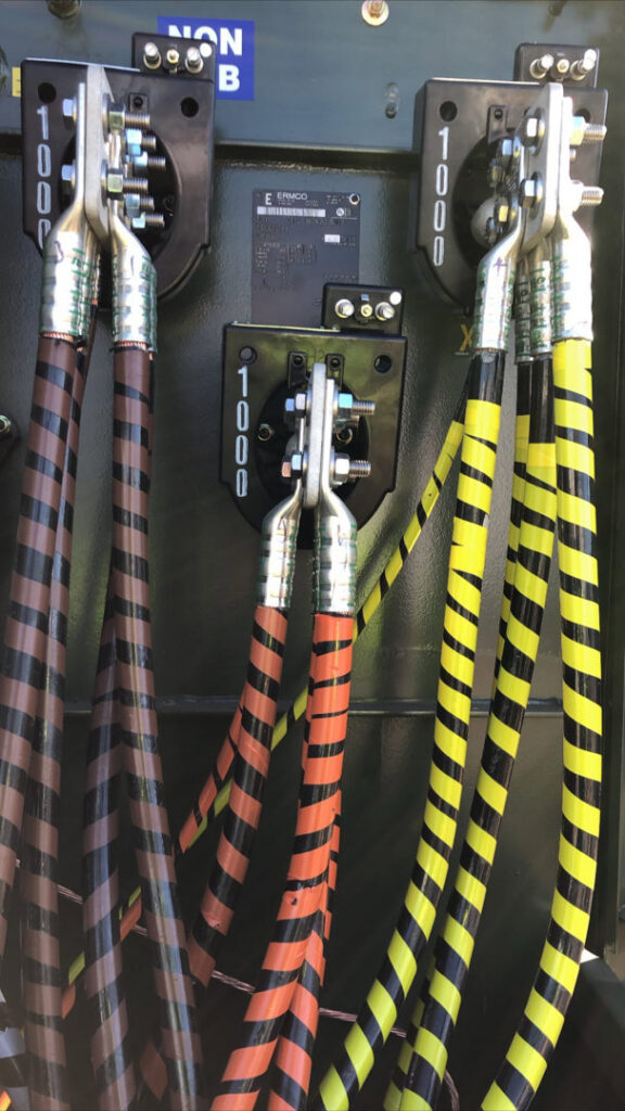Heavy-duty electrical cable connections with striped insulation inside an electrical enclosure by E & E Electric in Post Falls, ID.