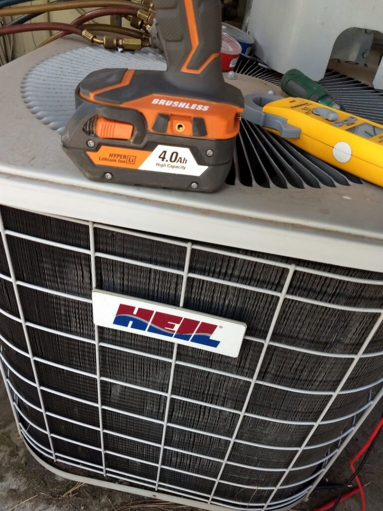 A HEIL HVAC condenser unit undergoing service or installation by Raytech Refrigeration, Heating & Cooling in Alamogordo, NM.