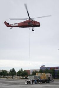 A helicopter lifting heavy HVAC equipment for a commercial installation by Chapman Air and Heat in Dallas, TX