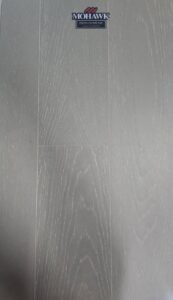 A close-up of a light-colored herringbone pattern flooring sample, available at Bronco Carpets and Flooring in Caldwell, ID.