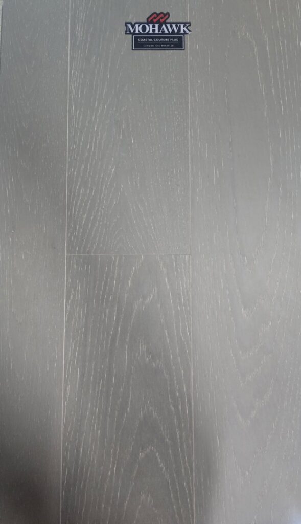 A close-up of a light-colored herringbone pattern flooring sample, available at Bronco Carpets and Flooring in Caldwell, ID.