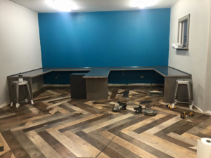 A commercial room with herringbone luxury vinyl plank flooring being installed by McCulloch Commercial Flooring in Fairbanks, AK