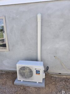 A Hessaire mini-split outdoor unit newly installed on a concrete pad by Quantum Cooling & Heating in Mesa, AZ.