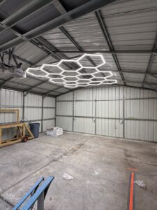 Unique hexagonal LED lighting installed on the ceiling of a large metal building by A Solid Connection Electrical Services in Brandon, FL.
