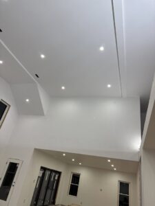 A large room with high ceilings featuring new recessed lighting installed by Ramos Electrical services inc in Brownsville, TX