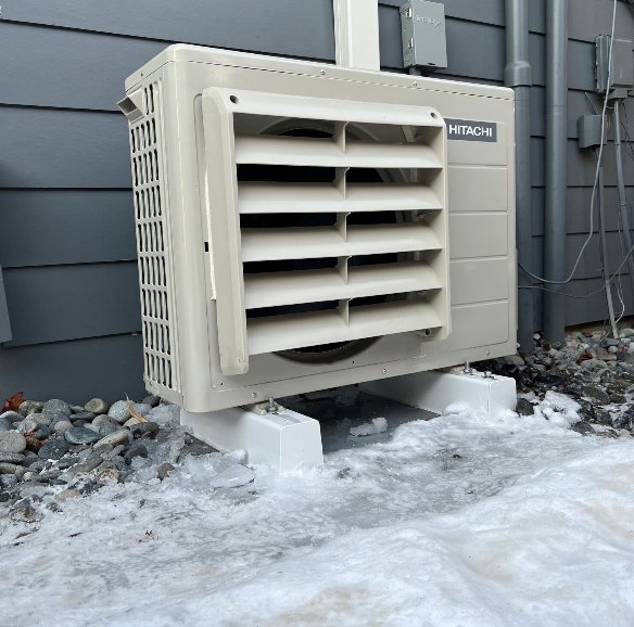 An outdoor Hitachi heat pump unit operating in winter conditions by JN Heating & Cooling in Eure, NC