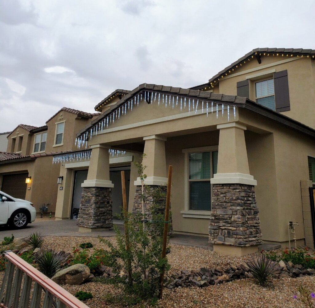A residential home with professionally installed icicle holiday lights by GET LIT Electrical Services LLC in Glendale, AZ.
