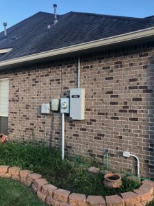 Exterior view of a home's electrical panel and conduit installation by Optimize Generator People in Baton Rouge, LA.
