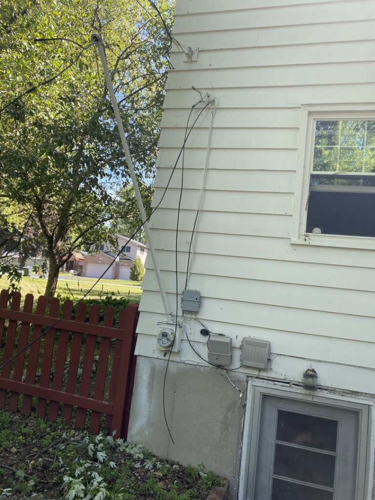 The electrical service entrance and meter on the exterior of a home, showing wiring work performed by AA Electric Contractors in Chicago, IL.