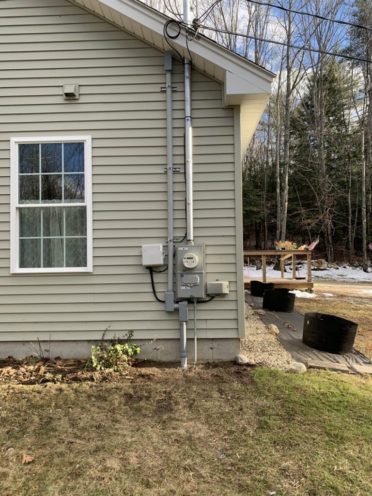 A residential electrical service entrance with meter and main disconnect, installed by Building Connections LLC in Auburn, ME.