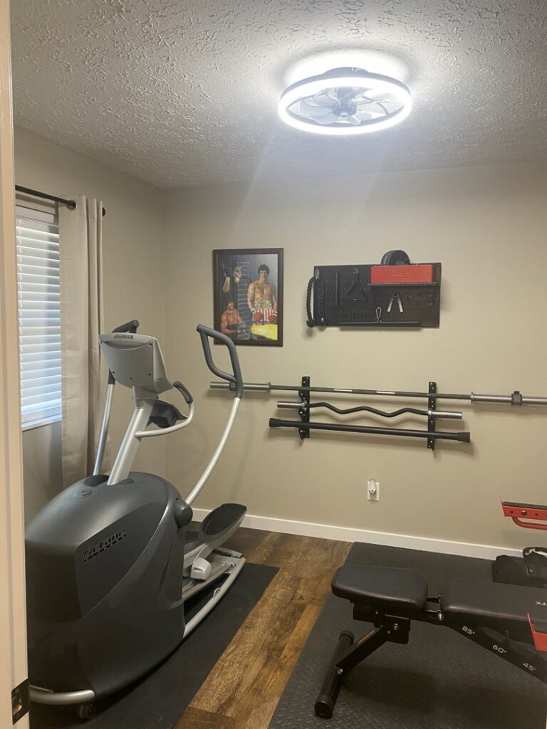 A home gym featuring a newly installed ceiling fan with integrated lighting by Peak Electric in Mount Washington, KY.