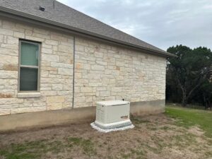 A Generac home standby generator professionally installed next to a stone house by Gen Central Power Systems in Houston, TX
