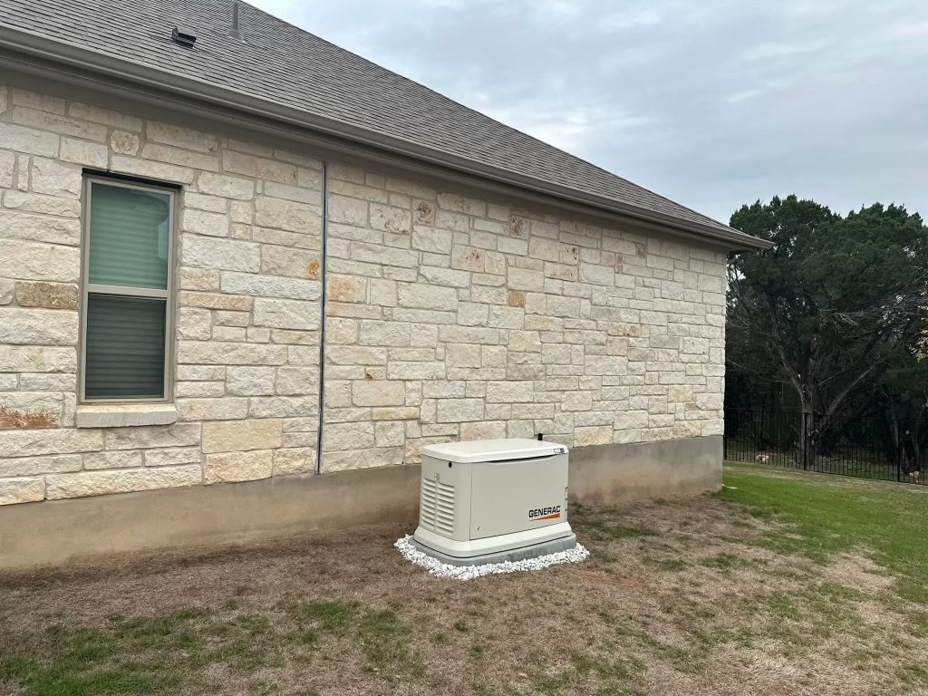 A Generac home standby generator professionally installed next to a stone house by Gen Central Power Systems in Houston, TX