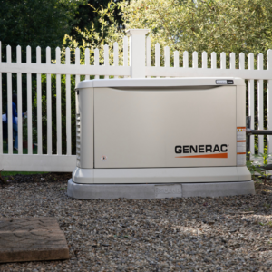 A Generac home standby generator installed on a gravel bed near a white fence by Generator Maintenance of Georgia in Atlanta, GA.