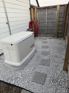 A home standby generator installed on a gravel bed by Optimize Generator People in Baton Rouge, LA.