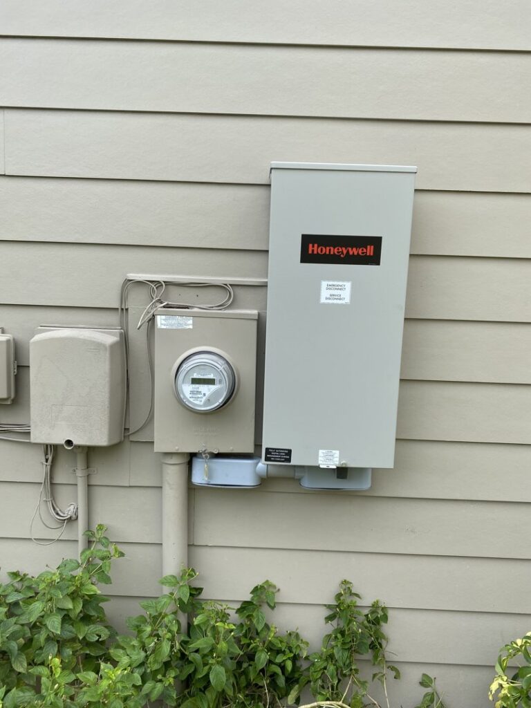 A newly installed Honeywell electrical panel and meter on the exterior of a home by Fuller Electrical Contractors, Inc. in Oldsmar, FL.
