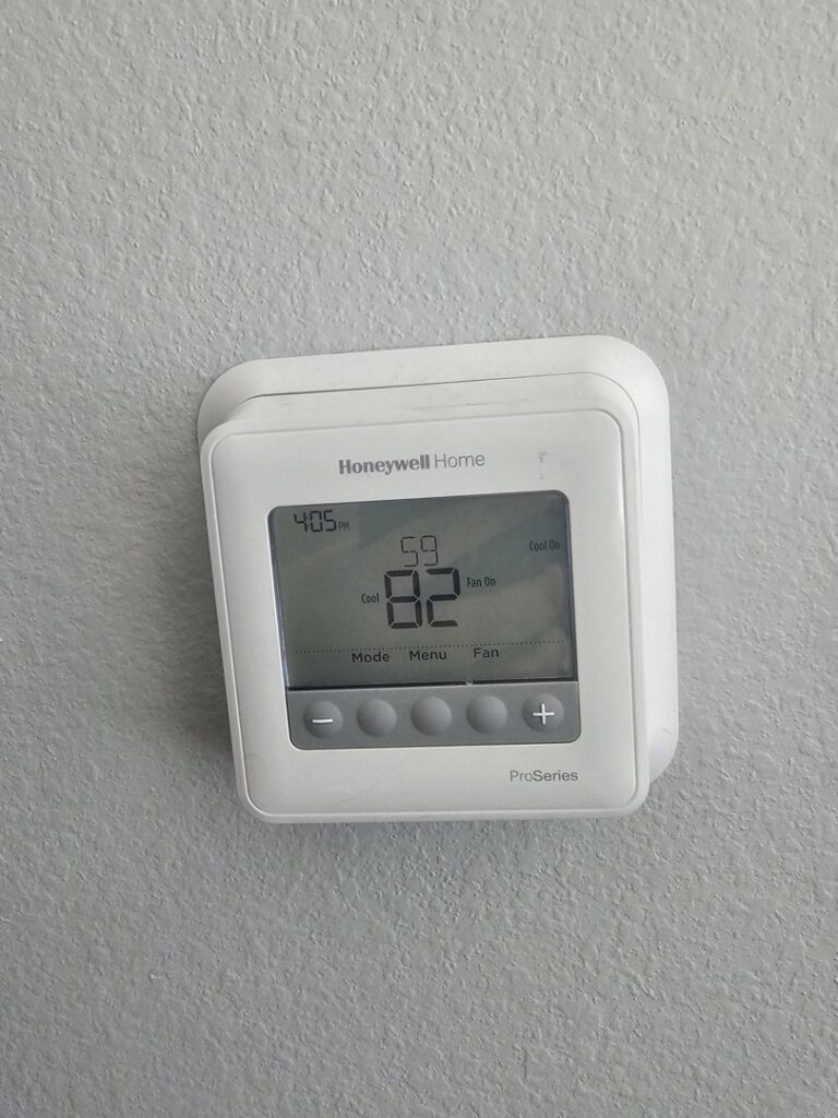 A Honeywell Home thermostat on a wall displaying temperature settings, serviced by Desert Air, LLC in Sun Valley, NV.