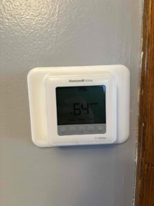 A Honeywell Home ProSeries thermostat displaying 64 degrees, installed by Service Pro Titans in Chicago, IL.