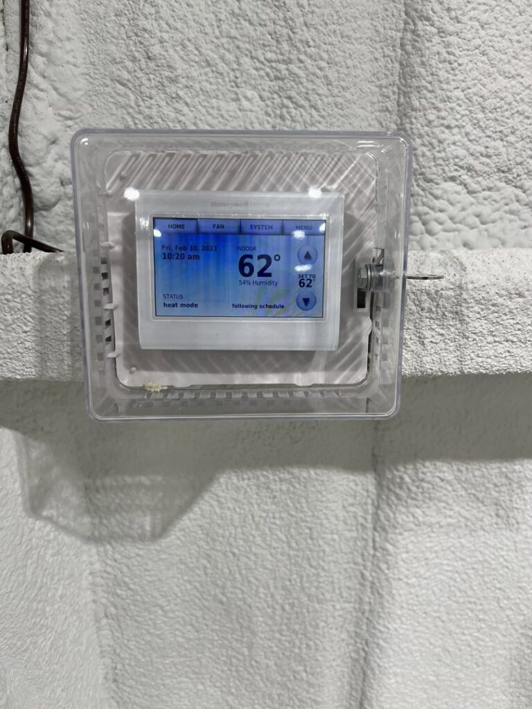 A Honeywell smart thermostat displaying 62 degrees, installed by Alpha HVAC LLC in Alexandria, LA.