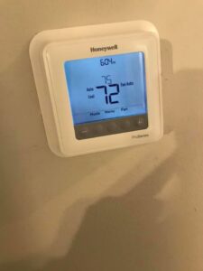 A modern Honeywell thermostat installed on a wall, representing services by Elite Heating & Cooling in Knoxville, TN.