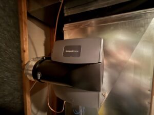 A Honeywell whole-house humidifier installed on ductwork by Neal Harris Service Experts in Overland Park, KS.