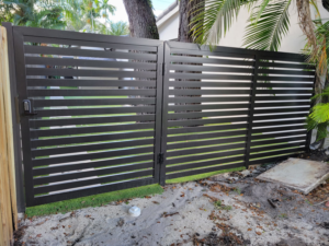 A dark gray horizontal slat gate with a keypad installed by Southeastern Fence Corp. in Pembroke Pines, FL.
