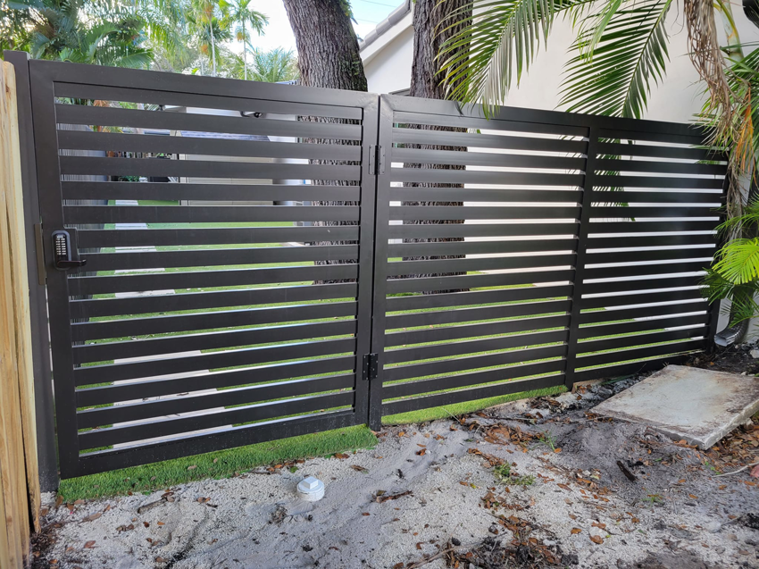 A dark gray horizontal slat gate with a keypad installed by Southeastern Fence Corp. in Pembroke Pines, FL.