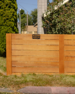 A modern horizontal slat wood fence with a small business sign, installed by Alpine Fencing in Everett, WA.