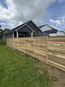 A modern horizontal slat wood fence installed in a residential backyard by Central Ohio Fence in Newark, OH.
