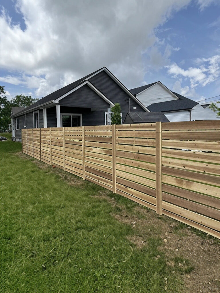 A modern horizontal slat wood fence installed in a residential backyard by Central Ohio Fence in Newark, OH.